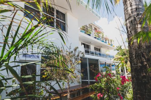a white building with plants in front of it at Numero Uno Beach House in San Juan