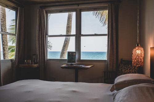 a bedroom with a bed and a view of the ocean at Numero Uno Beach House in San Juan