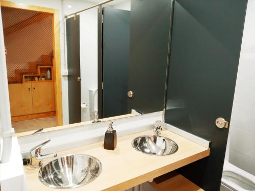 a bathroom with two sinks and a large mirror at Albergue O Peirao in A Guarda