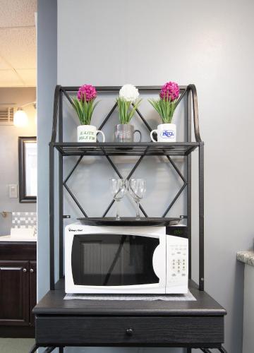 a black shelf with a microwave and flowers on it at Music Valley Studio - No Stairs - Opryland Area in Nashville