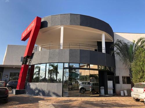 a building with a dealership with cars parked in front at Hotel 7 in Três Lagoas