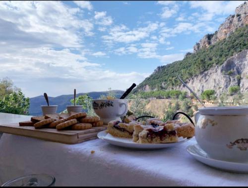 a table with two plates of pastries and cups of coffee at Le Terrazze Sul Pollino B&B in Civita