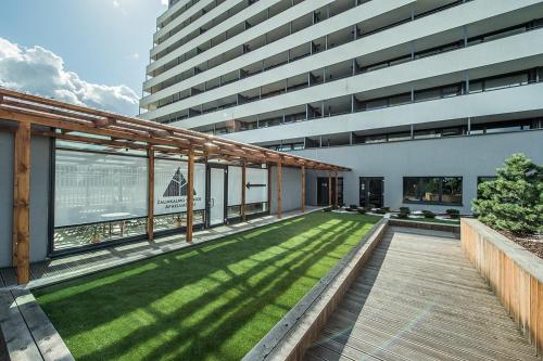 a large building with a lawn in front of it at Zaliakalnio terasos apartamentai in Kaunas