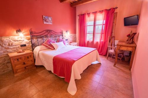 a bedroom with a bed and a table and a window at Cal Ros in Calonge de Segarra