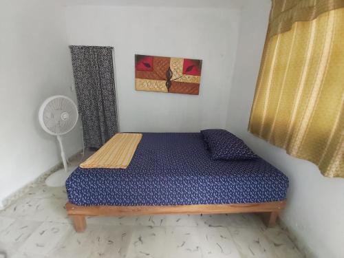 a small bedroom with a bed in a room at Delmar Hostal in Bacalar
