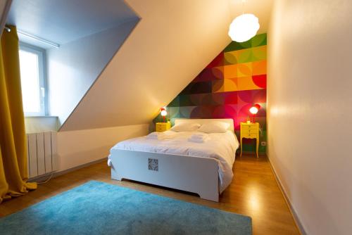 1 dormitorio con 1 cama y una pared colorida en APPARTEMENT LE VITAMINE - topbnb dijon en Dijon