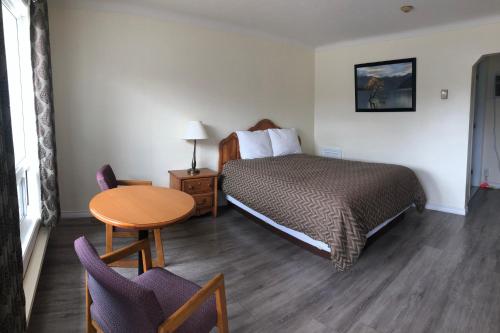 康沃爾的住宿－世紀汽車旅館，酒店客房带一张床、一张桌子和椅子