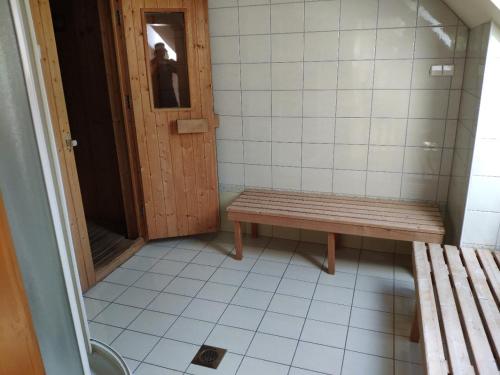 a small bathroom with a bench and a door at Antela, 142 m2 appartment for 12 person in Mariborsko Pohorje in Hočko Pohorje