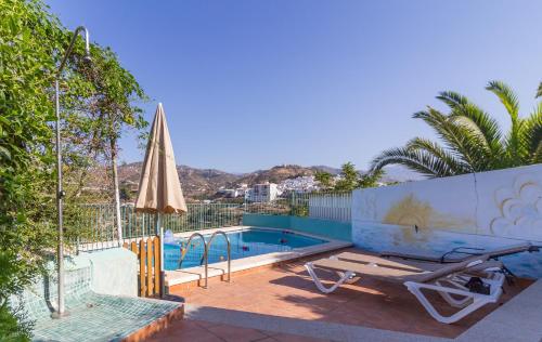 a swimming pool with a bench and an umbrella at Alojamiento Colina del Sol in Torrox