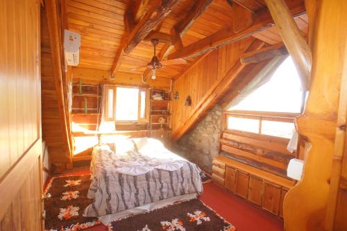 a bedroom with a bed in a wooden cabin at Cabañas Troncopiedra in Huerta Grande