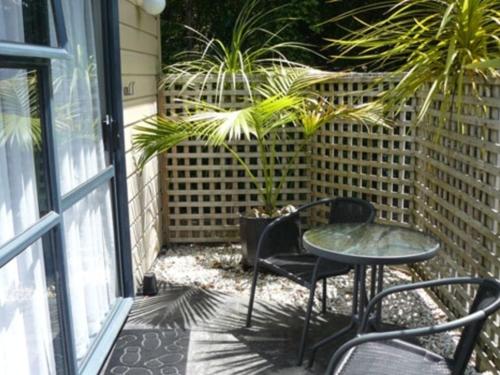 a patio with a table and chairs and plants at Cheviot Park Motor Lodge in Whangarei