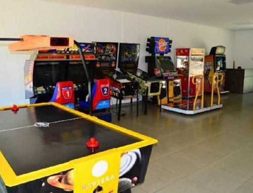 a room with a ping pong table and arcade games at Caldas Novas Riviera in Caldas Novas