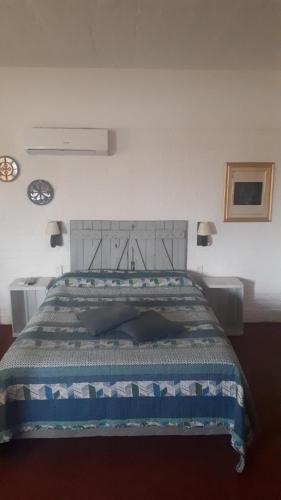 a bedroom with a bed with a blue and white comforter at Familia Moro in Piriápolis