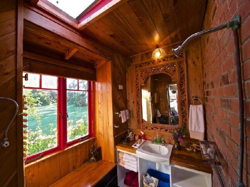 a bathroom with a sink and a mirror at Bethells Beach Cottages in Bethells Beach