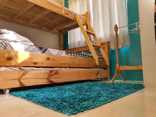 sypialnia z drewnianym łóżkiem piętrowym i niebieskim dywanem w obiekcie 409 El Montalvo Bldg San Jose Residencias w mieście Santa Rosa