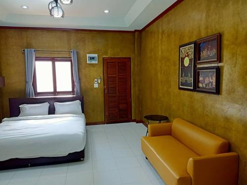 a bedroom with a bed and a couch at Superkids Resort in Phitsanulok