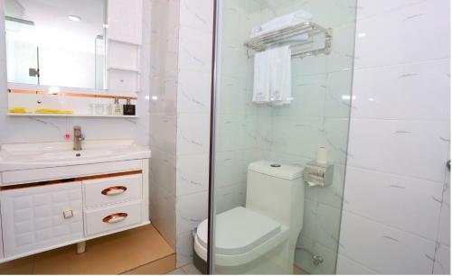 a white bathroom with a toilet and a sink at Guangzhou Junshan Hotel - Shuttle bus for Canton Fair in Guangzhou