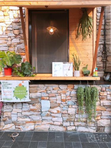 a building with a stone wall with plants on it at Sun Moon Heart Hostel in Puli