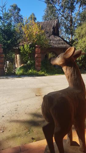 a statue of a horse standing in front of a house at Cabañas Rukas Licantén in Licantén