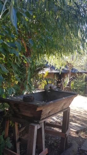 a wooden boat sitting on a picnic table under a tree at Cabañas Rukas Licantén in Licantén