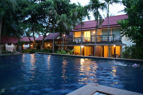 a hotel with a swimming pool in front of a building at Palita Lodge - SHA Plus in Haad Rin