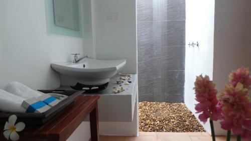 a bathroom with a sink and a shower at The Reef Resort in Koh Kradan