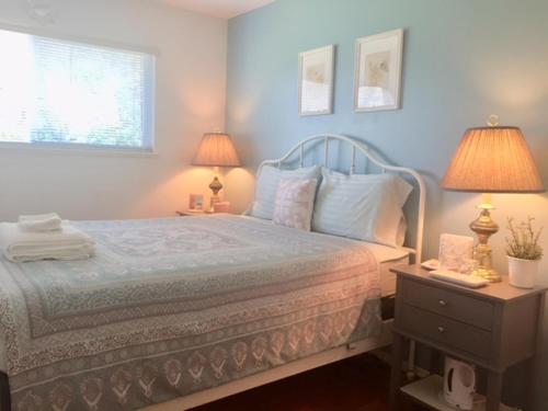 ein Schlafzimmer mit einem Bett mit blauen Wänden und 2 Lampen in der Unterkunft Sun House in Vancouver