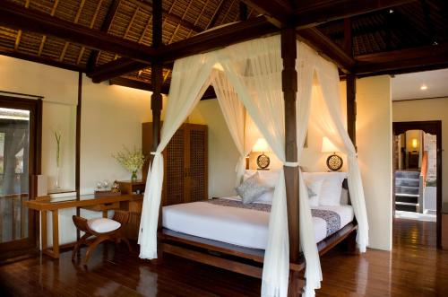 a bedroom with a bed and a desk at Kamandalu Ubud - CHSE Certified in Ubud
