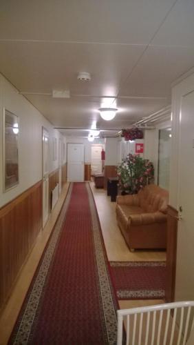 a hallway with couches and a red carpet at Hotelli Sandels in Siilinjärvi