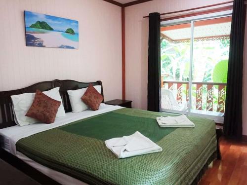 a bedroom with a bed with two towels on it at Anawin Bungalows in Ao Nang Beach