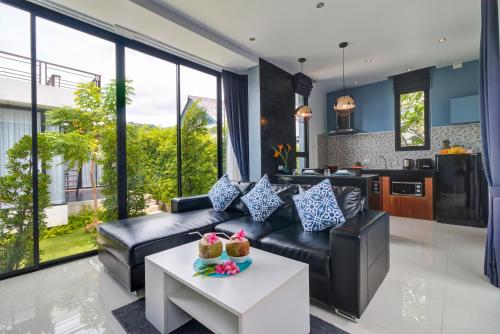 a living room with a couch and a table at Coco Layma Villa, Samui in Lamai