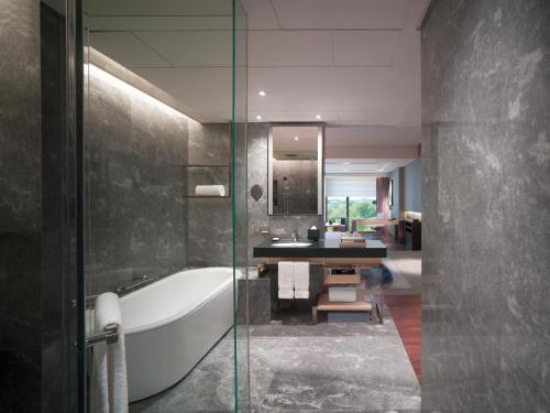 فندق نيو وورلد بكين في بكين: حمام مع حوض استحمام ومغسلة