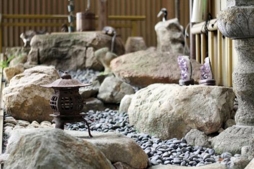 a model of a garden with rocks and a small statue at Miyajima Hotel Makoto in Miyajima