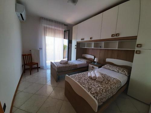 a bedroom with two beds with shoes on them at DOMUS MARIS Viserba, Speciale offerta di Pasqua,Spiagge e Centro a 100 mt, a 5 minuti RIMINIFIERA Offerta THE COACH EXPERIENCE GINNASTICA IN FESTA RIMINI 2024 in Rimini