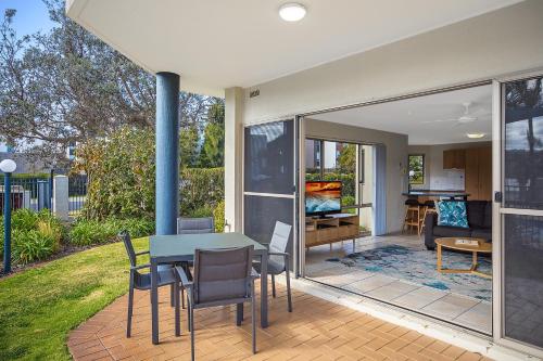 a house with a table and chairs on a patio at Sails Luxury Apartments Merimbula in Merimbula