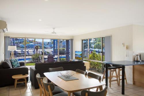 a living room with a couch and a table at Sails Luxury Apartments Merimbula in Merimbula