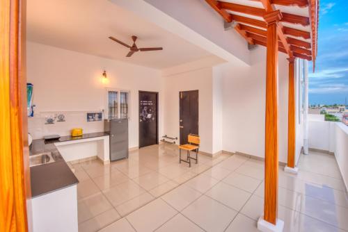 a kitchen with white walls and a ceiling fan at La Maison Charu in Puducherry