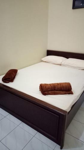 Una cama con dos toallas marrones. en Nusin 54 Homestay, en Malang