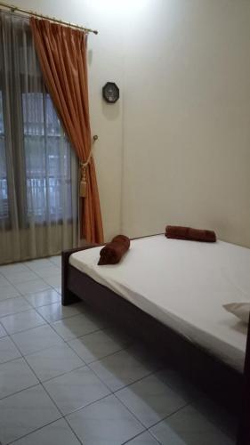 Bett in einem Zimmer mit Fenster in der Unterkunft Nusin 54 Homestay in Malang