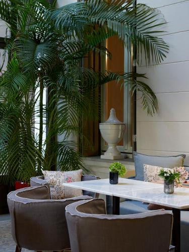a restaurant with tables and chairs and a palm tree at Marpessa Hotel & Spa in Agrinion