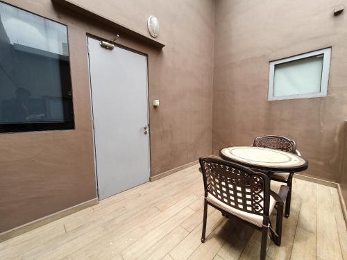 a room with a table and a chair and a door at Arton Boutique Hotel in Singapore
