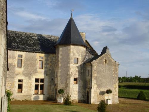 an old stone building with a black roof at Manoir Du Bois Noblet in Louerre