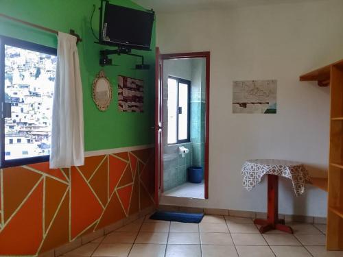 a bathroom with a shower and a television on the wall at Taxco de mis amores in Taxco de Alarcón