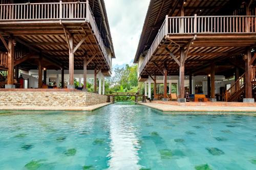 une piscine d'eau en face d'un bâtiment dans l'établissement Villa Atas Awan, à Payangan