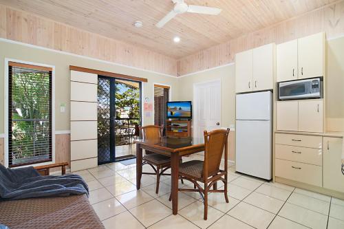 a kitchen with a dining room table and refrigerator at South Gladstone Motel in Gladstone