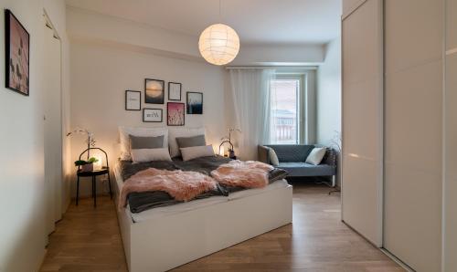 ein Schlafzimmer mit einem Bett und einer Hängeleuchte in der Unterkunft New & luxurious apartment SUPERIOR by Arctic Homes in Rovaniemi