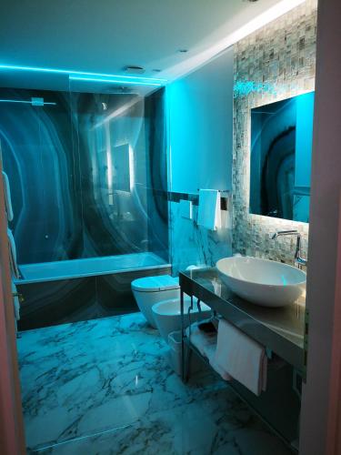 a blue bathroom with two sinks and a toilet at Hotel Campo Marzio in Vicenza