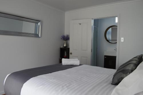 a bedroom with a large white bed with a window at Tongariro Springs Boutique Suites in National Park