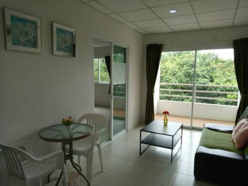 a living room with a couch and a table at โรงแรมเวลลิงตัน in Ban Chak Phai