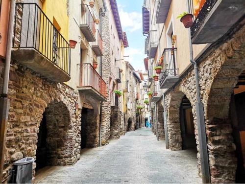 an alley between two stone buildings in a city at Duplex a la plaça Major in El Pont de Suert